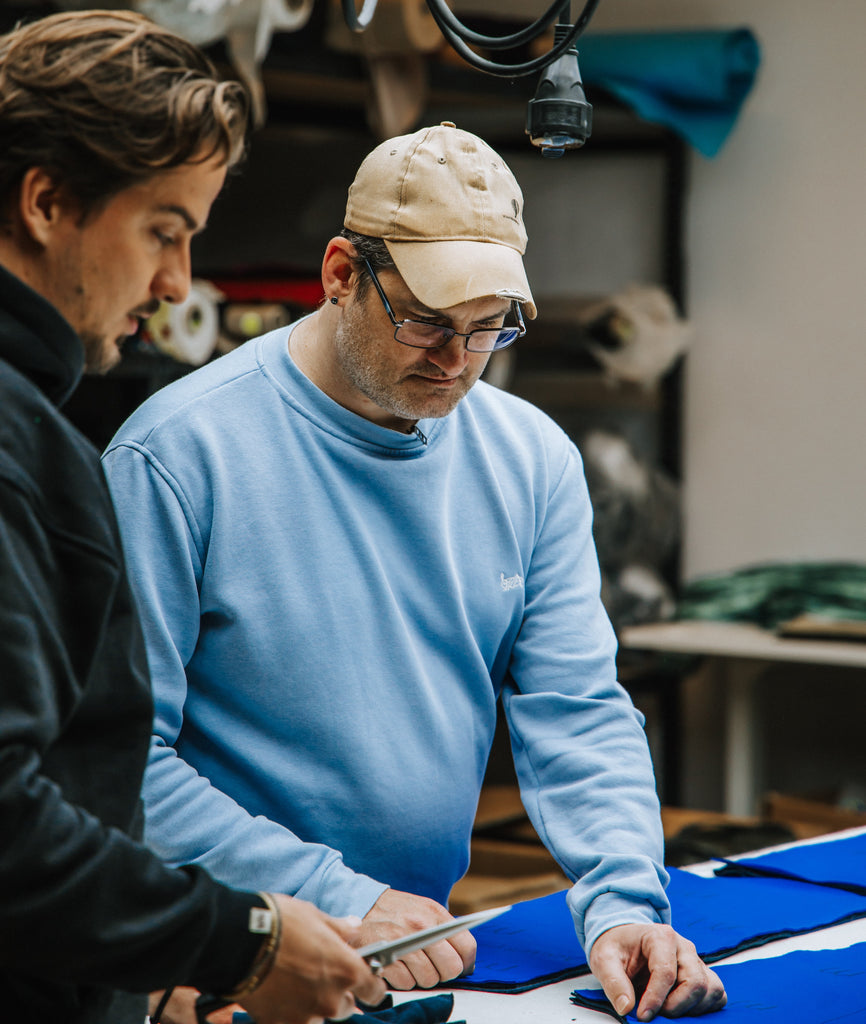 Een close-up van duurzame, handgemaakte kleding uit Nederland. Zachte stoffen in natuurlijke tinten, met aandacht voor detail en vakmanschap. Een voorbeeld van slow fashion die stijl en duurzaamheid combineert. Bedrijfskleding